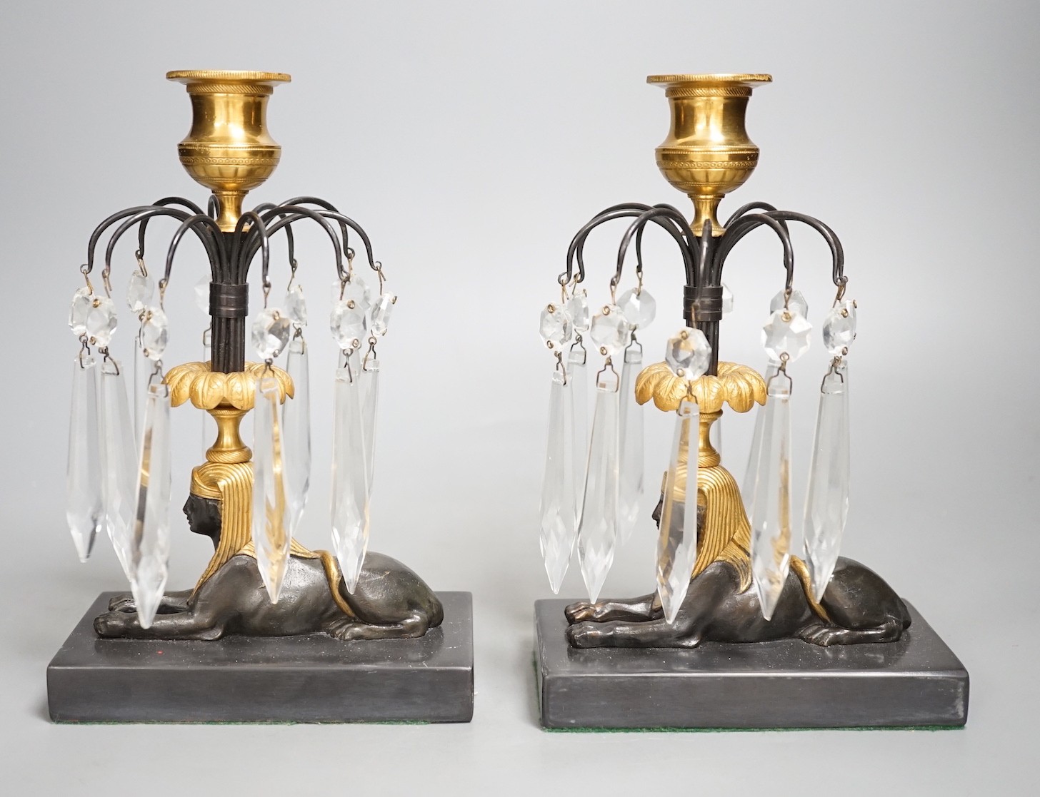 A pair of gilt bronze and glass lustre drop 'sphinx' candlesticks, 21cm